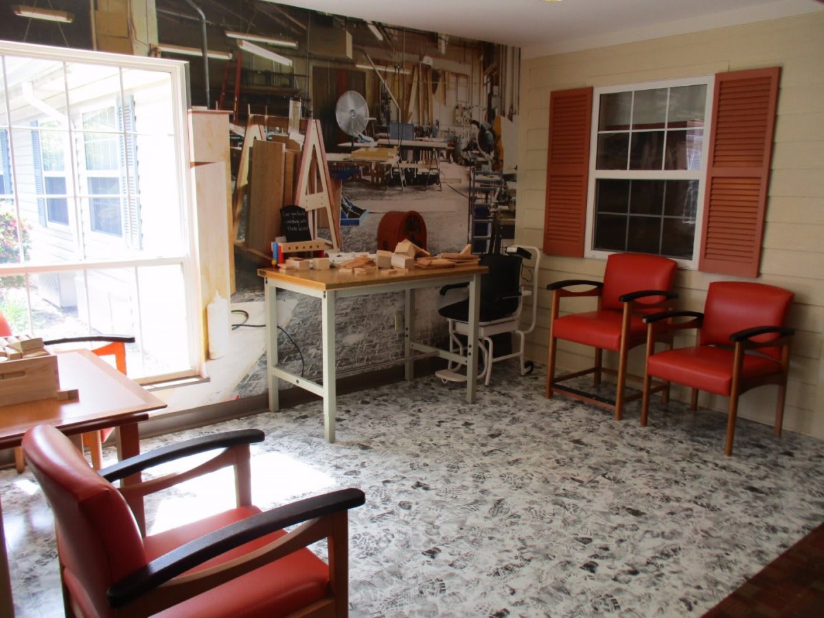 Vintage barbershop interior with red chairs and a workbench adorned with tools.