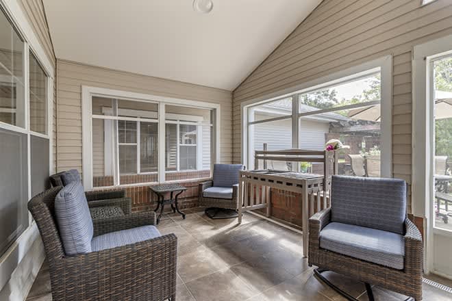 A cozy sunroom with comfortable seating and ample natural light.