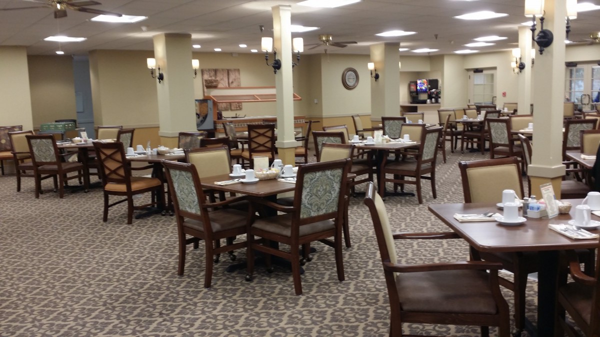 An empty dining room with neatly arranged tables and chairs, ready for service.