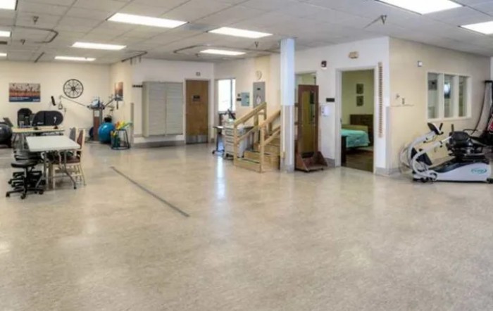 A spacious physical therapy and rehabilitation room with various equipment.