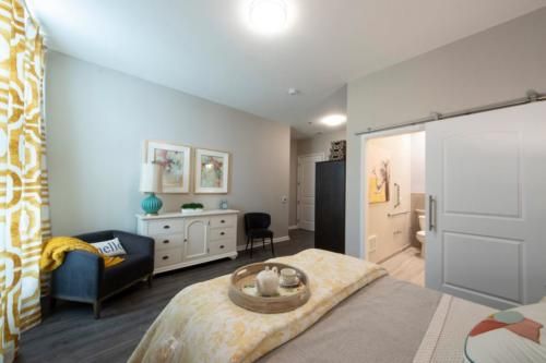 A modern bedroom featuring a comfortable bed, dresser, and stylish decor.