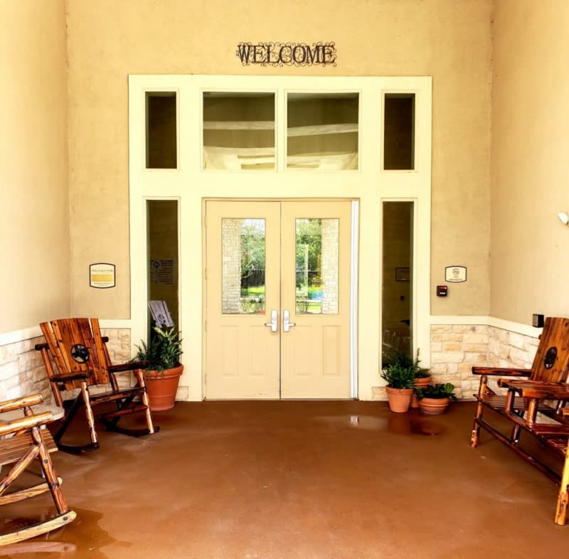 A welcoming entrance with rocking chairs and potted plants.