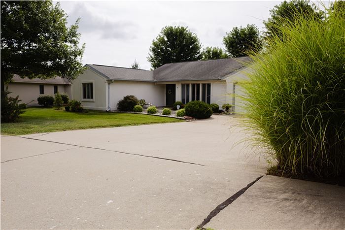 A suburban house with a large driveway and well-maintained front yard.