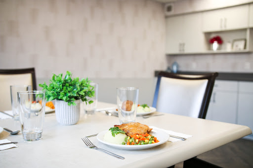 A beautifully set dining table with a delicious meal and decorative plant.