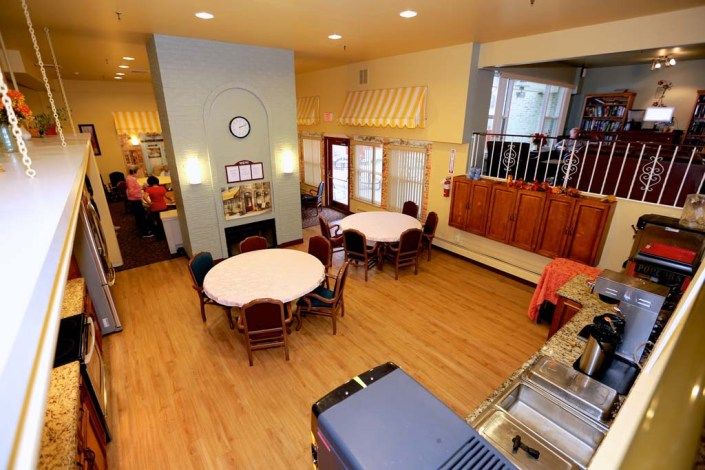 A cozy dining space with round tables and wooden flooring.