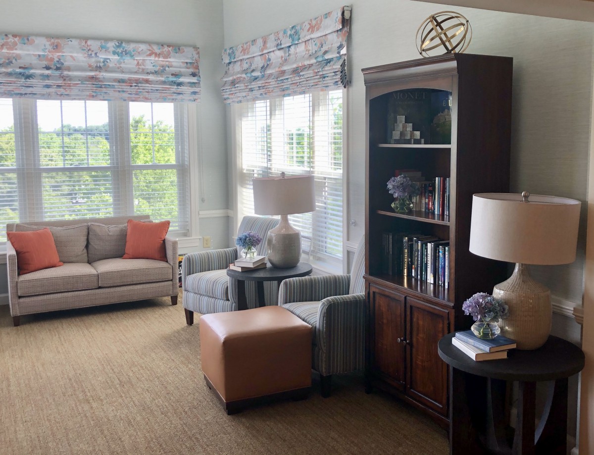 A cozy living room with sofas, an armchair, a bookshelf, and decorative items.