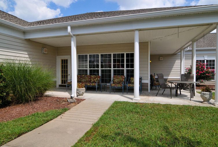 A cozy patio area with outdoor seating and a well-maintained lawn.