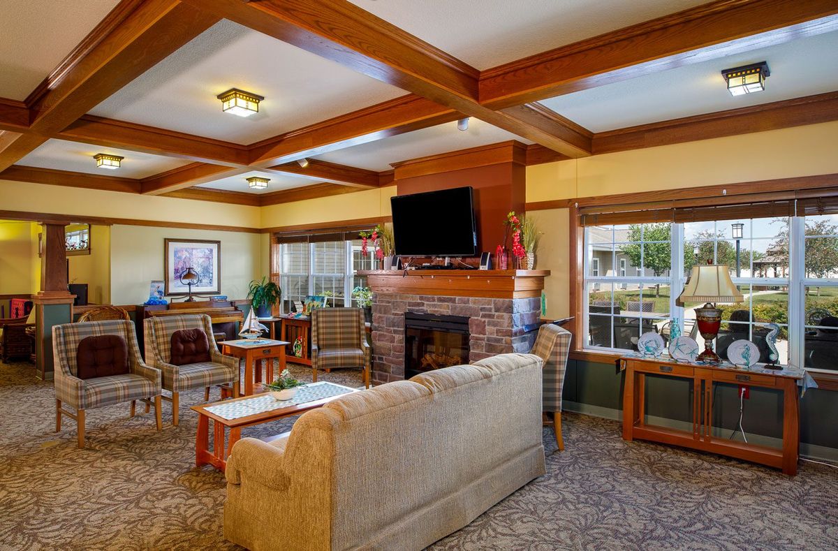A cozy living room with wooden beams, a fireplace, and comfortable seating.