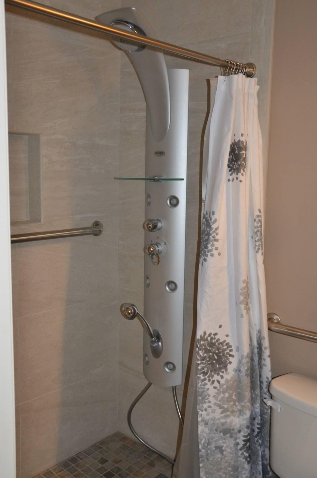 A modern bathroom with a sleek shower system and decorative shower curtain.