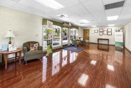 A spacious and inviting lobby featuring elegant wooden flooring and comfortable seating.