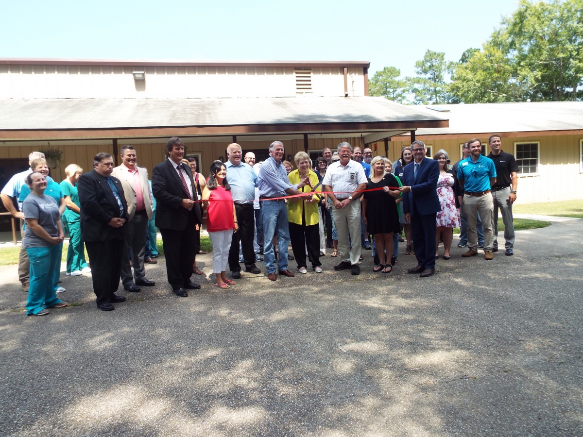 A group of people gathered outdoors for a ribbon-cutting ceremony.