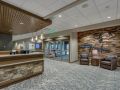 A modern lobby with a reception desk and seating area.