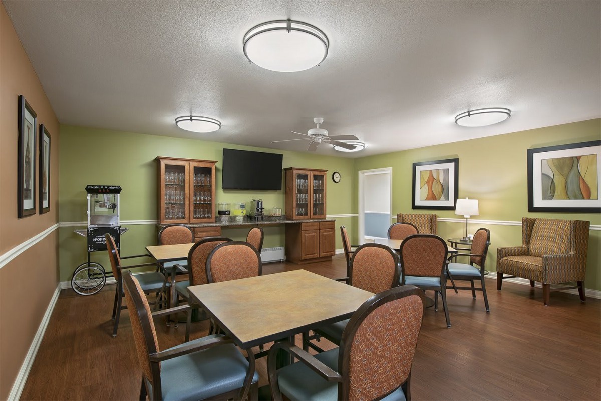 A modern dining area with tables, chairs, and a television.