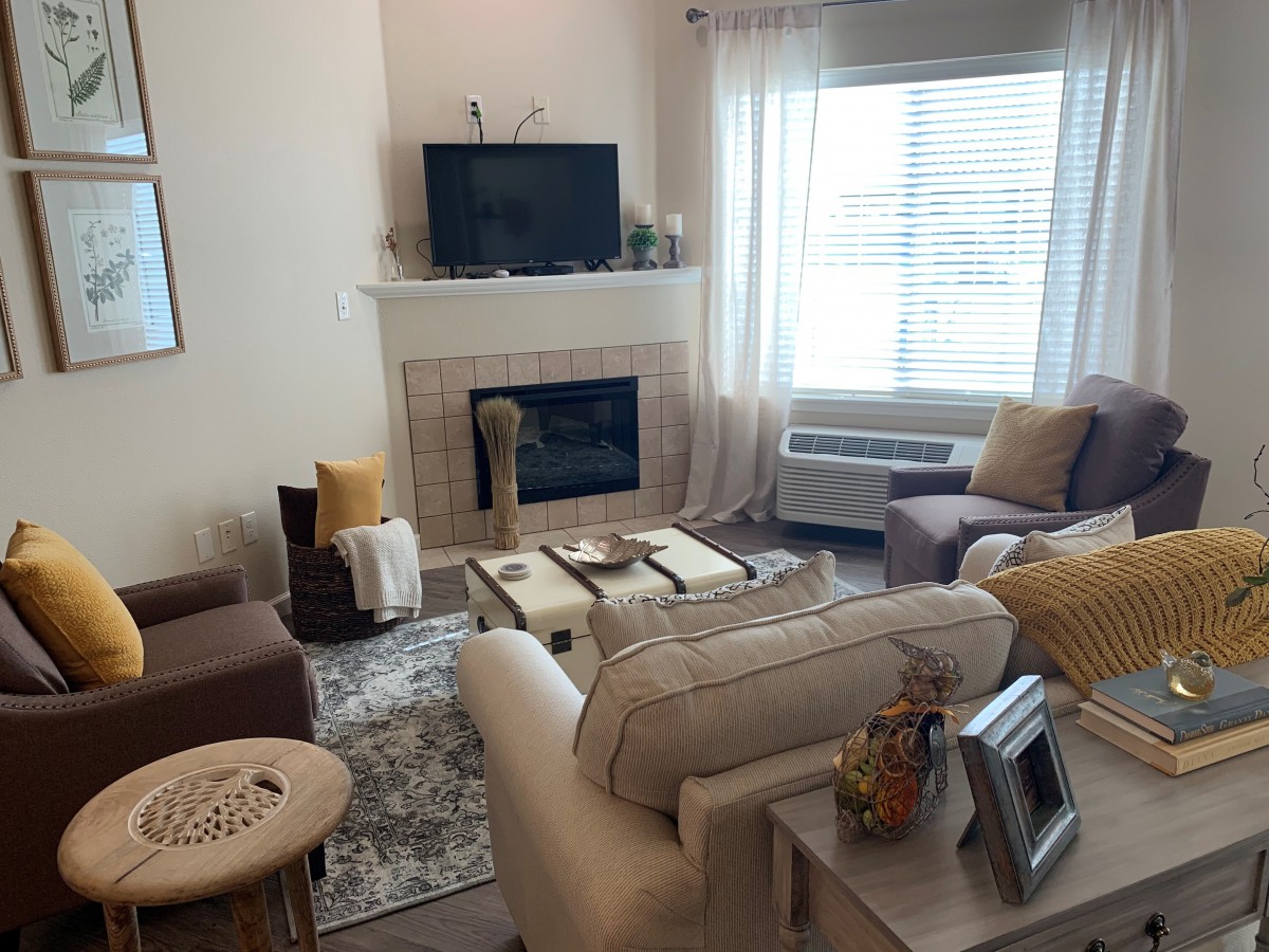 A cozy living room with comfortable seating, a fireplace, and a TV.