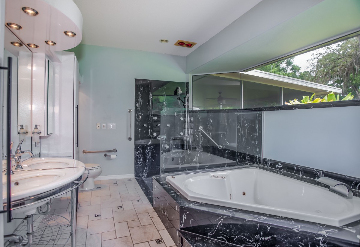 A luxurious bathroom featuring a marble bathtub and sleek modern design.