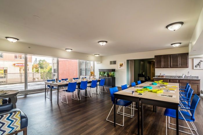 A modern classroom interior with blue chairs and ample natural light.