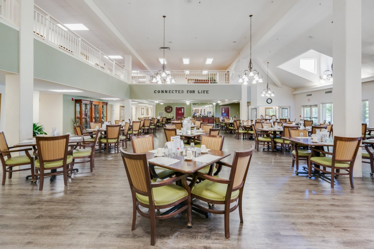 A spacious and well-lit dining room with neatly arranged tables and chairs.