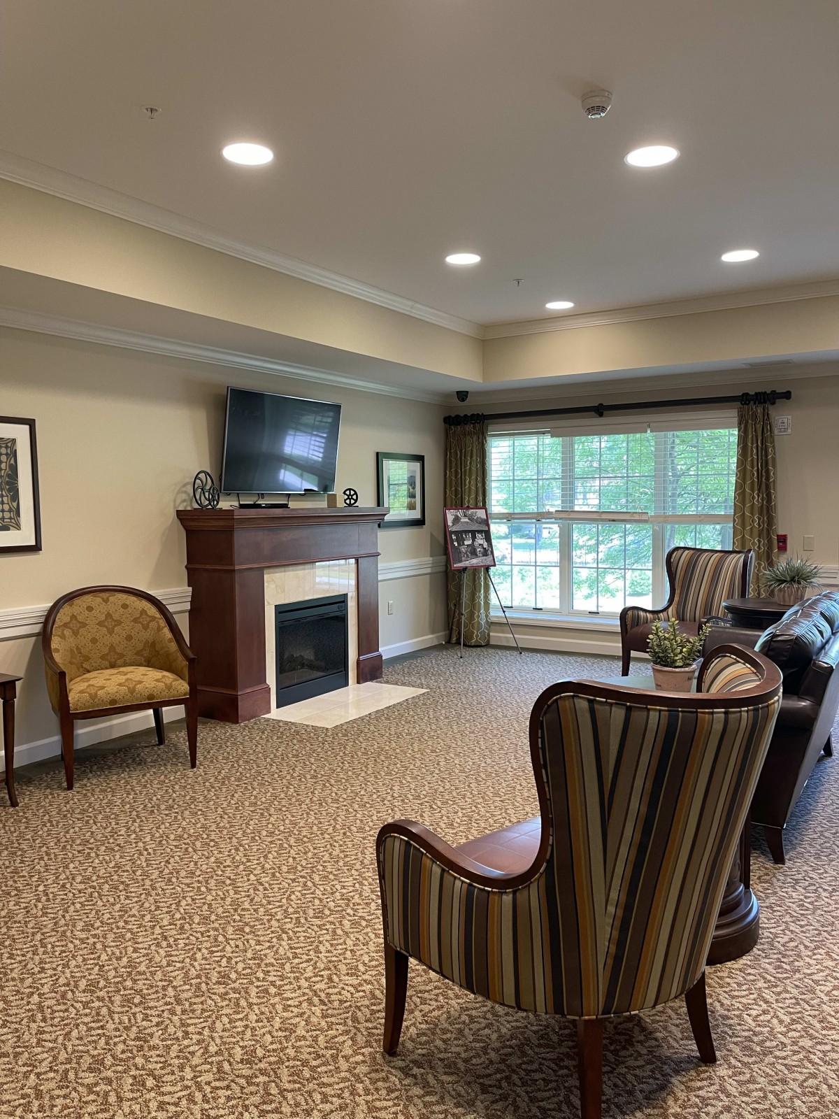 A cozy living room with a fireplace, television, and comfortable chairs.
