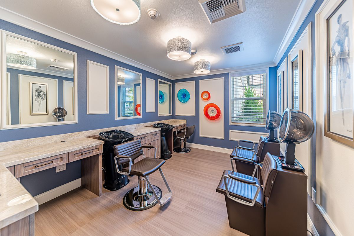 A modern salon interior with styling stations and barber chairs.