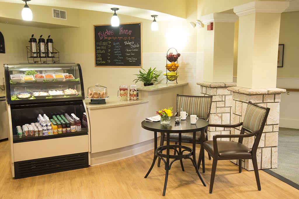 A cozy cafe interior with a small seating area and a menu board.