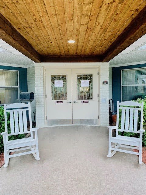 A welcoming porch entrance with two white rocking chairs.