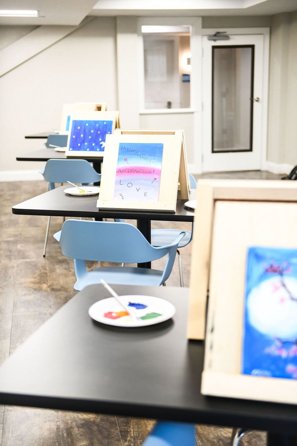 Easels set up for an art class with canvases and painting materials ready for creativity.