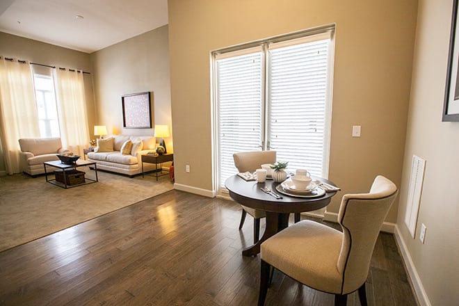 A cozy living room and dining area featuring wood flooring, comfortable seating, and ample natural light.