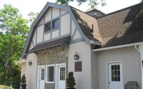 A Tudor-style residential building with a stone facade and steep roof.