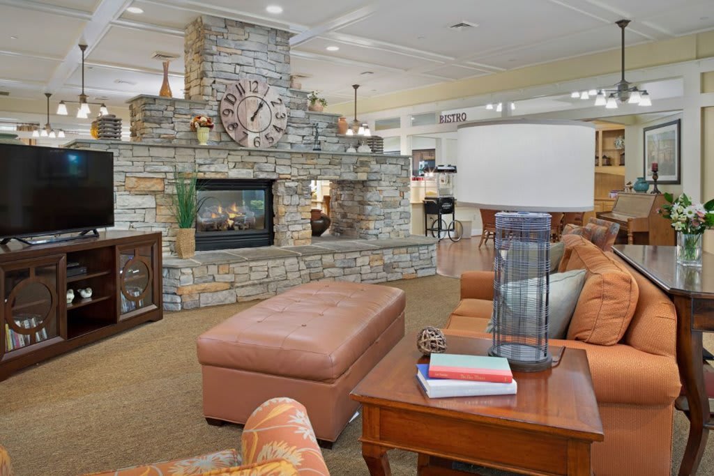 A cozy living room featuring a stone fireplace and leather furniture.