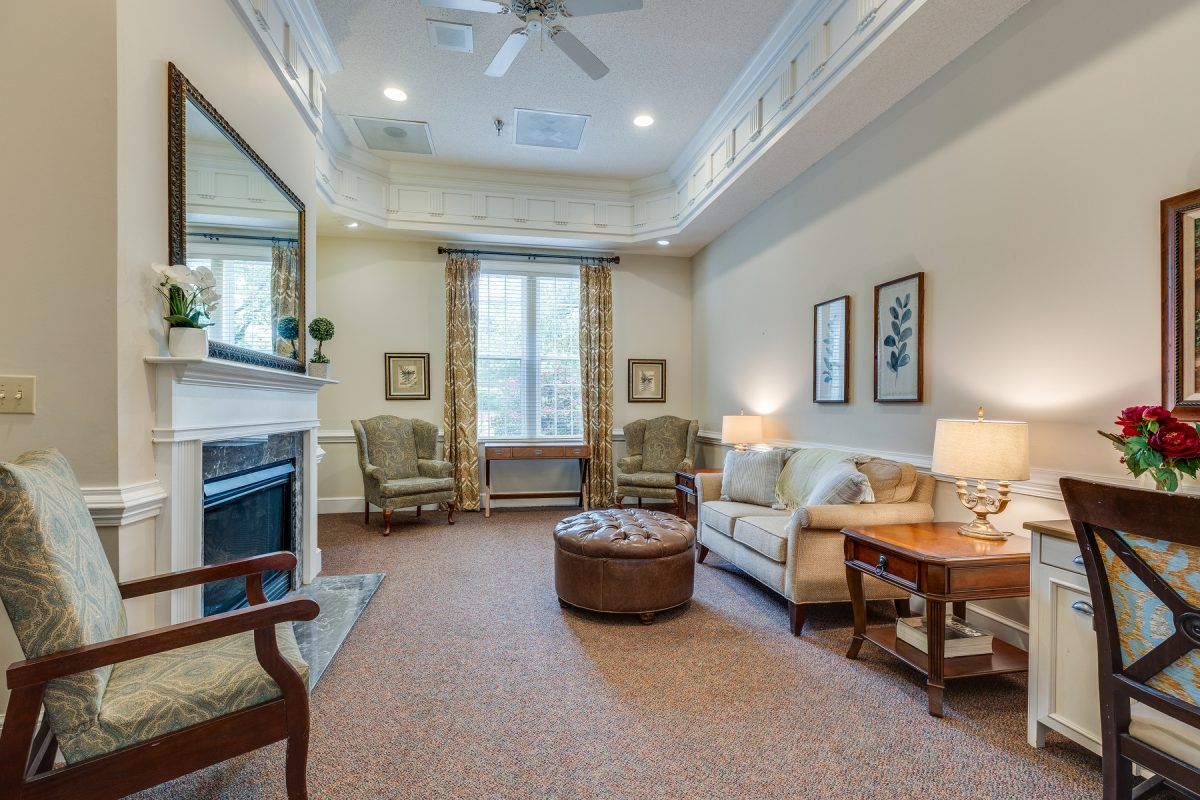 A cozy living room featuring a sofa, chairs, and a fireplace, with elegant interior decor.