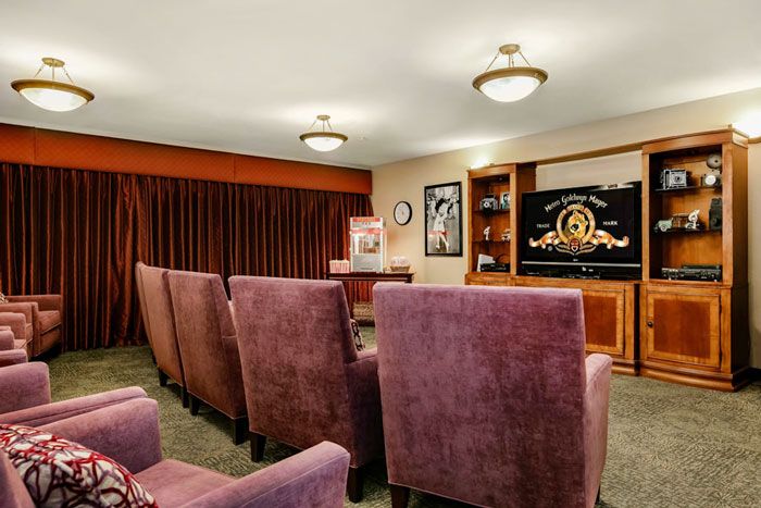 A cozy home theater with plush seating and a large screen for viewing movies.
