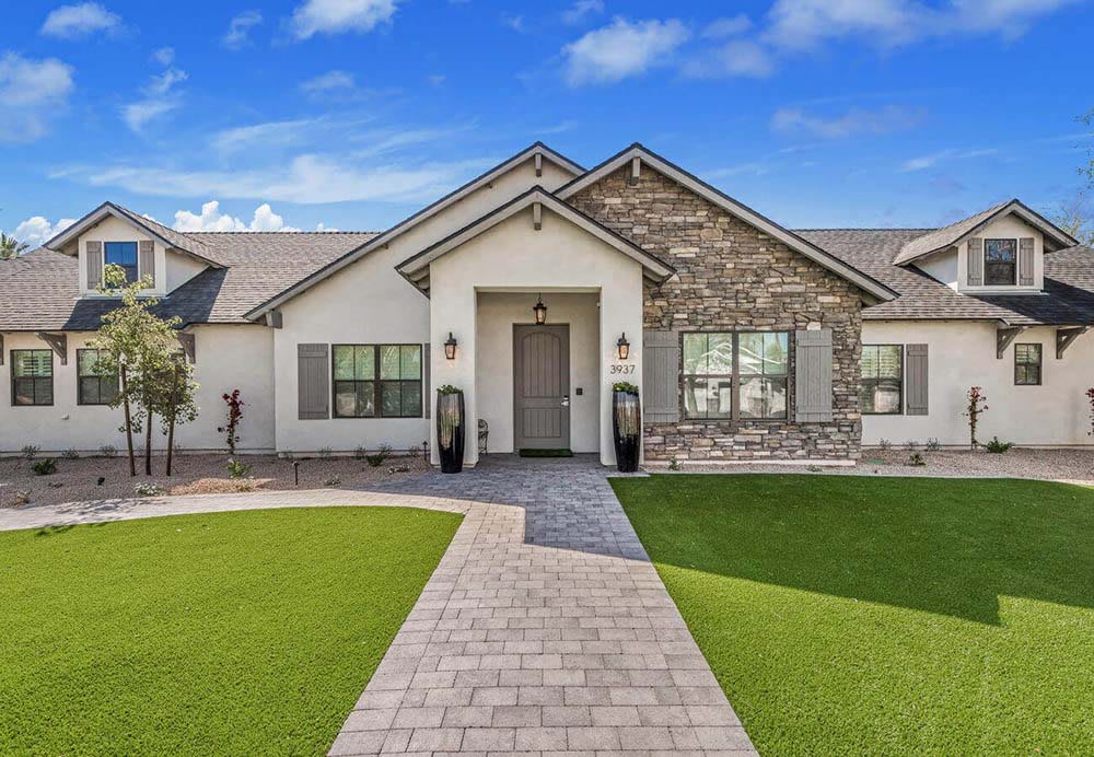 A modern residential house with a well-maintained front yard and stone accents.