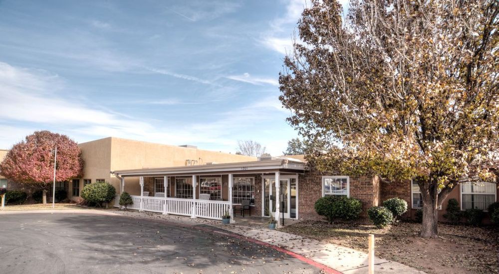 A building exterior with a covered entrance and landscaped surroundings.