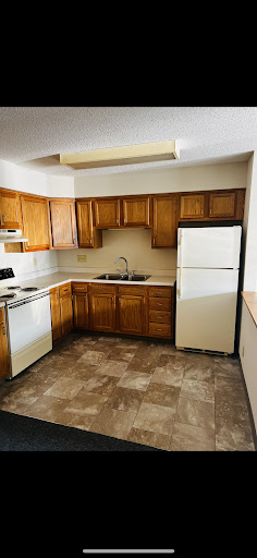 A spacious kitchen featuring wooden cabinets and essential appliances.