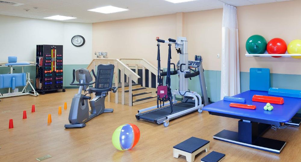A well-equipped gym with various exercise machines and rehabilitation equipment.
