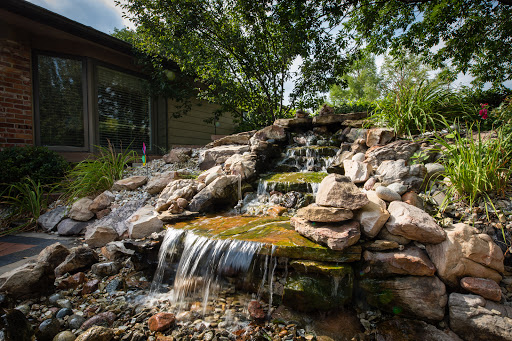 A serene waterfall cascading over rocks in a beautifully landscaped garden.