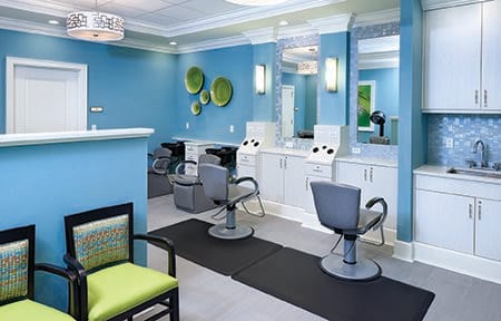 A modern hair salon with blue walls, mirrors, and styling chairs.