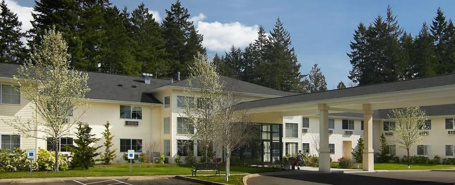 A modern hotel building surrounded by trees.