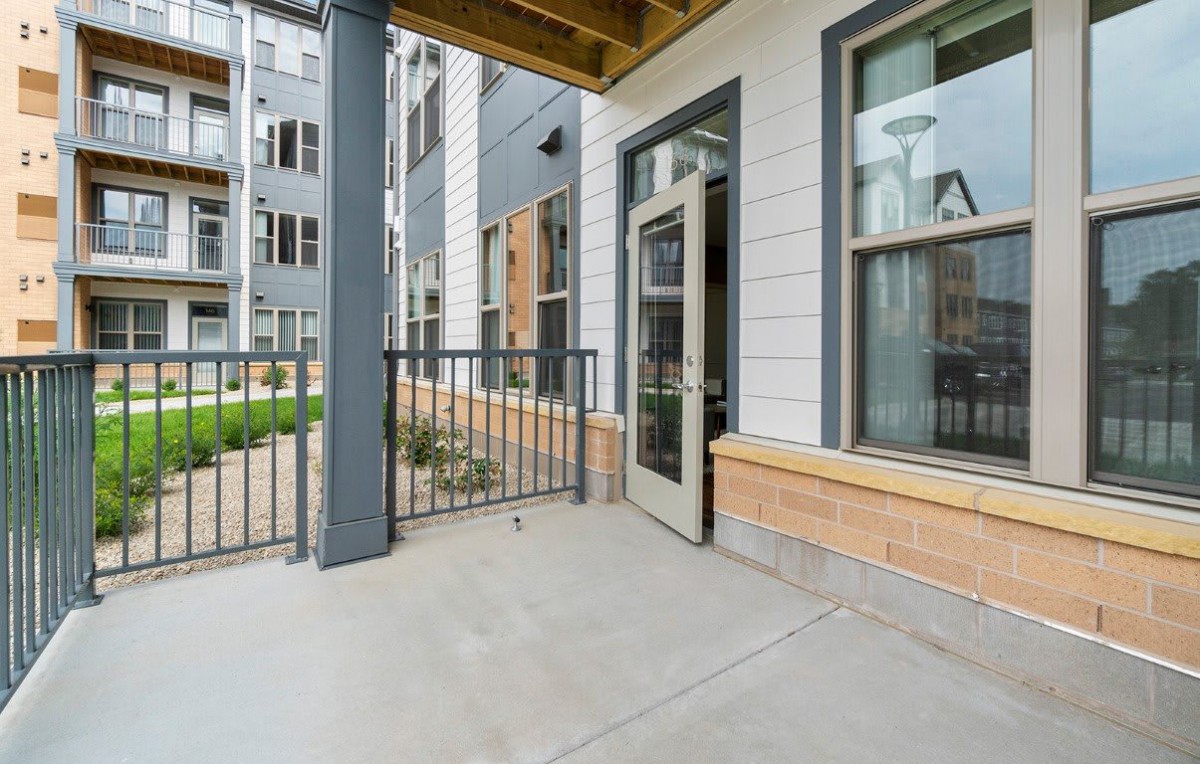 A view of an apartment's outdoor patio area with modern architectural design.