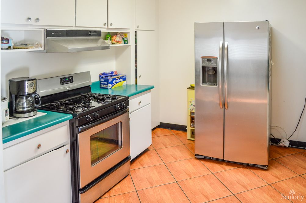 A modern kitchen with stainless steel appliances and tiled flooring.