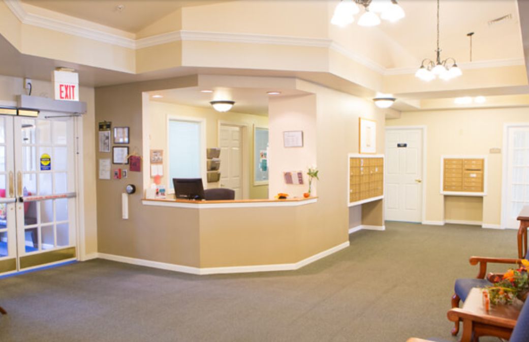 A spacious and well-lit reception area with a desk and seating.