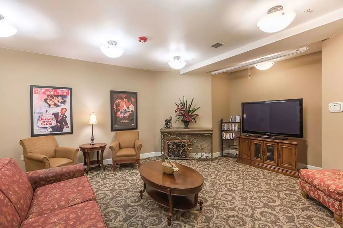 A cozy living room with a television, comfortable seating, and elegant decor.