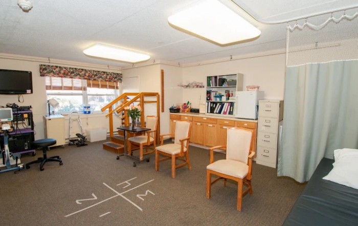 A well-lit office space with chairs, a desk, and shelving.