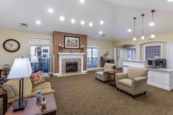 A modern living room with a fireplace, sofas, and ceiling lights creating a cozy ambiance.