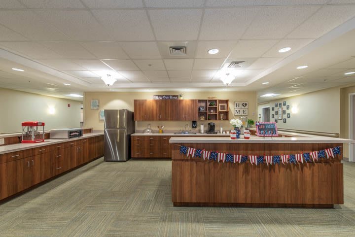 A spacious office kitchen with wooden cabinets, countertops, and festive decorations.
