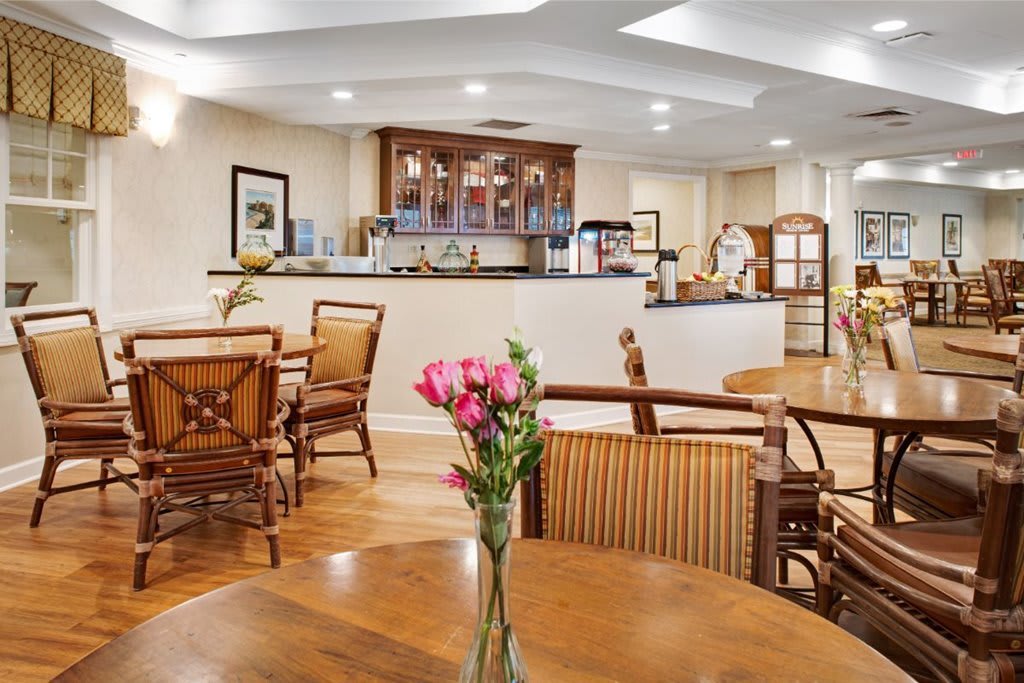A cozy dining area with wooden furniture and a vase of flowers on the table.