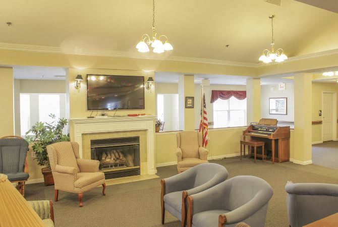 A cozy living room with a fireplace, television, seating area, and decorative lighting.