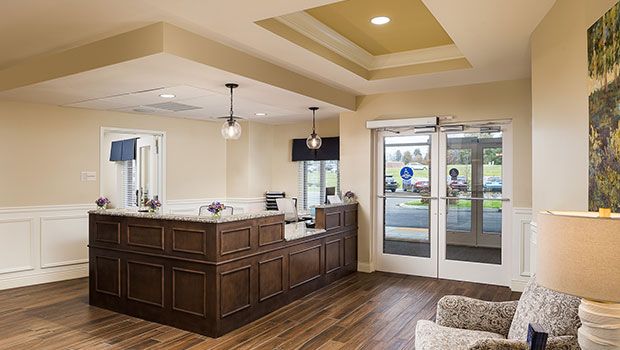 A modern reception area with wooden flooring and stylish lighting.