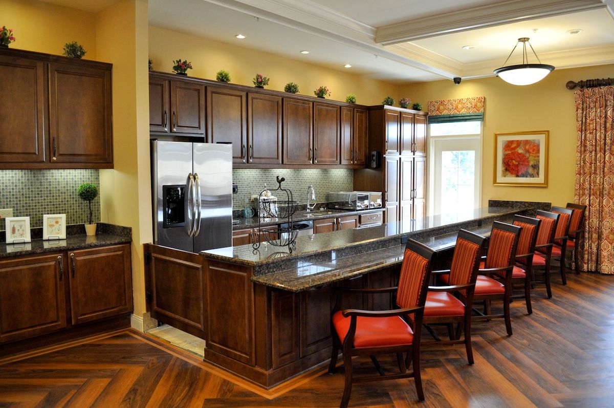 A modern kitchen with dark wood cabinets and a large island featuring bar stools.