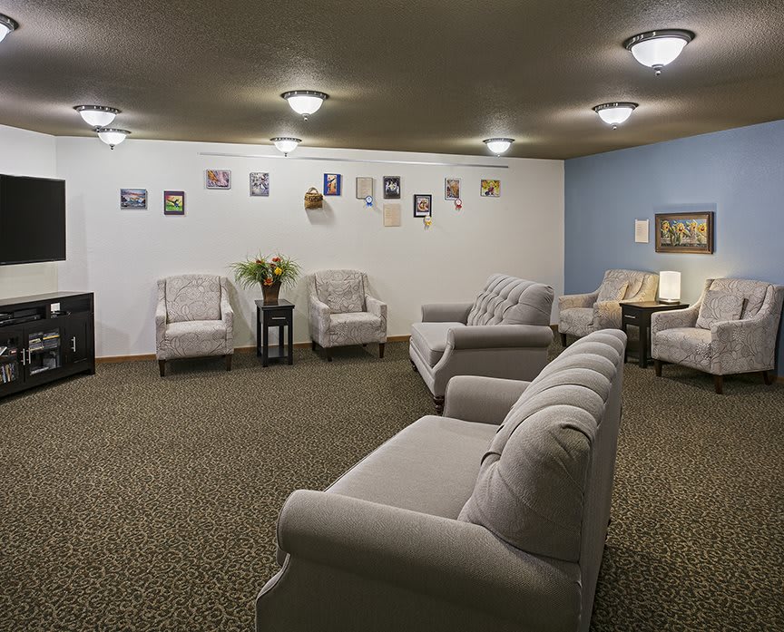 A spacious waiting room with comfortable seating and decorated walls.